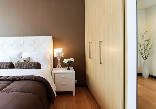 neutral Scandinavian bedroom with layered bedding and warm bedside lighting